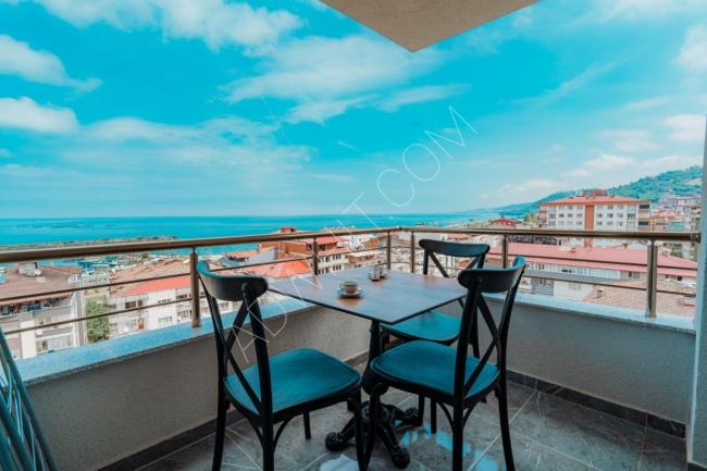 Hotel apartments in Trabzon, three rooms, a hall, a kitchen, two bathrooms, and a balcony with a sea view