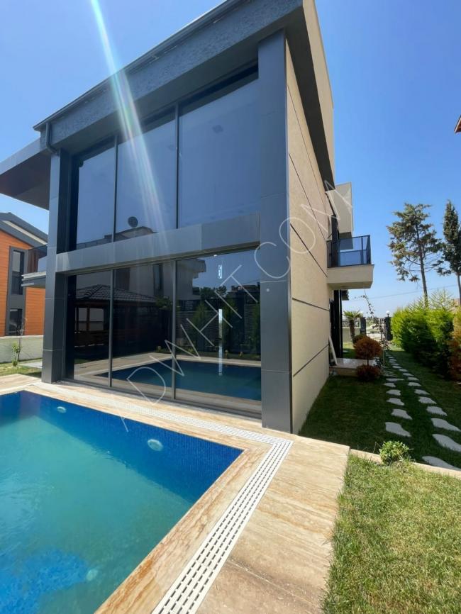 4+2 villa with a swimming pool, covering an area of 510 square meters, within walking distance to the sea, with three floors and a unique design.