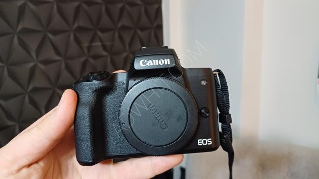 Canon m50 camera with its original box, an extra battery, and a memory card