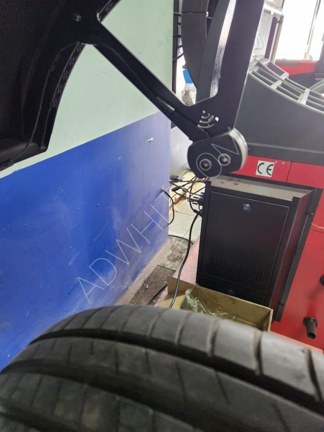 Tire balancing machine with a touch screen, equipped with laser and sonar