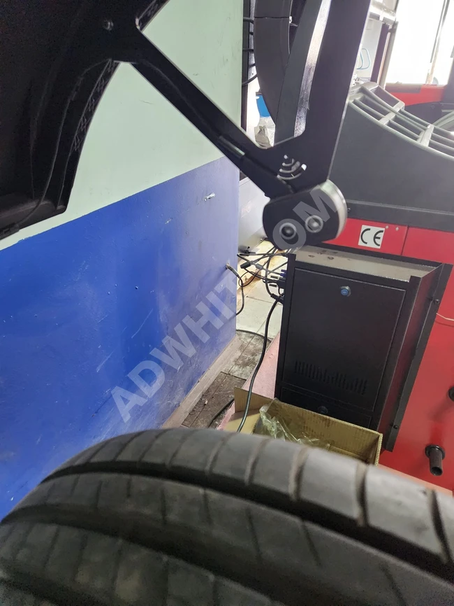 Tire balancing machine with a touch screen, equipped with laser and sonar